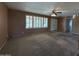 Inviting living room with neutral walls, plush carpeting, and large shuttered windows at 3740 E Mercer Ln, Phoenix, AZ 85028
