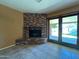 Living room with a brick fireplace, sliding glass doors to the patio, and tile flooring at 3740 E Mercer Ln, Phoenix, AZ 85028