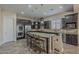 Spacious kitchen with dark cabinets, stainless steel appliances, and a large granite island with bar stool seating at 3925 E Elmwood St, Mesa, AZ 85205