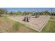 A community playground with swings, climbing rocks, and a globe-shaped climbing toy, all in a sand base at 3925 E Elmwood St, Mesa, AZ 85205
