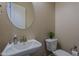 This powder room features a pedestal sink, round mirror, and a plant on top of the toilet at 3925 E Elmwood St, Mesa, AZ 85205