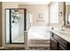 Bright bathroom with a separate shower and tub, dark cabinets, and a glass block window for natural light at 3994 E Grand Canyon Pl, Chandler, AZ 85249