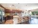 Spacious kitchen features dark wood cabinets, stainless steel appliances, and an island with bar seating at 3994 E Grand Canyon Pl, Chandler, AZ 85249