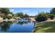 Serene pond with rocky waterfall and bridge amidst green foliage and flowering shrubs under a sunny sky at 3994 E Grand Canyon Pl, Chandler, AZ 85249
