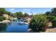Scenic pond featuring a charming waterfall and a quaint pedestrian bridge under a bright, sunny sky at 3994 E Grand Canyon Pl, Chandler, AZ 85249
