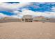 Large gravel backyard with block wall, covered patio with seating, and view of neighboring houses at 4061 N 308Th Ln, Buckeye, AZ 85396