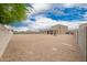 A large gravel backyard, showcasing the home's rear elevation and covered patio, enclosed by block wall at 4061 N 308Th Ln, Buckeye, AZ 85396