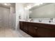 Bright bathroom with double sink vanity, tile floors, and a shower-tub combo at 4061 N 308Th Ln, Buckeye, AZ 85396