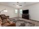 Cozy bedroom features neutral walls, plush carpet, a ceiling fan, and a large dresser with TV above at 4061 N 308Th Ln, Buckeye, AZ 85396