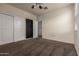 Bedroom with carpet flooring, ceiling fan, and a pair of white closet doors at 4061 N 308Th Ln, Buckeye, AZ 85396