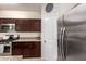 Well-equipped kitchen with stainless steel appliances, granite countertops, and dark wood cabinetry at 4061 N 308Th Ln, Buckeye, AZ 85396