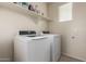 Bright laundry room featuring modern washer and dryer, overhead shelving and natural light from the window at 4061 N 308Th Ln, Buckeye, AZ 85396