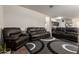Comfortable living room featuring leather reclining sofas and a modern rug at 4061 N 308Th Ln, Buckeye, AZ 85396
