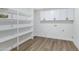Bright laundry room with built-in shelves and white cabinets, offers convenient storage solutions at 4347 E Catalina Cir, Mesa, AZ 85206