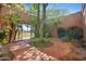 Secluded courtyard featuring a decorative gate, mature trees, and custom brickwork at 4518 E Solano Dr, Phoenix, AZ 85018