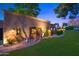 Beautiful home exterior with lush landscaping, a charming gate, and elegant outdoor lighting at 4518 E Solano Dr, Phoenix, AZ 85018