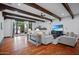 Spacious living room featuring wood floors, exposed beams, and French door access to the outdoors at 4518 E Solano Dr, Phoenix, AZ 85018