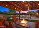 Relaxing outdoor seating area with a fire pit overlooking the pool and lush landscaping at 4518 E Solano Dr, Phoenix, AZ 85018