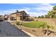 Home backyard with a small deck, artificial grass, and desert landscaping at 4547 E Buist Ave, Phoenix, AZ 85044
