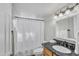 Clean bathroom with granite counter vanity, toilet, and shower with white curtain at 4547 E Buist Ave, Phoenix, AZ 85044