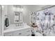 Cozy bathroom with sink, mirror, toilet, and decorative shower curtain, combining style and functionality at 4547 E Buist Ave, Phoenix, AZ 85044