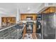 Open-concept kitchen with granite counters, black appliances, wood cabinets and a breakfast bar at 4547 E Buist Ave, Phoenix, AZ 85044