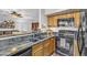 Kitchen featuring black appliances, granite countertops, wood cabinets, and a view into the living space at 4547 E Buist Ave, Phoenix, AZ 85044