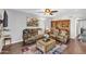 Living room with comfortable seating, ceiling fan, hardwood floors, decorative rug, and bookcase at 4547 E Buist Ave, Phoenix, AZ 85044