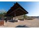 An outdoor covered picnic shelter features natural rock walls, shade roof, and concrete seating at 4547 E Buist Ave, Phoenix, AZ 85044
