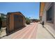 Side yard shed and brick paver path lead to backyard patio with seating at 4623 W Solano S Dr # South, Glendale, AZ 85301