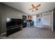 Carpeted bedroom with ceiling fan, television, shelves, and gaming desk at 4623 W Solano S Dr # South, Glendale, AZ 85301