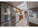 Kitchen with stainless steel refrigerator, wood cabinets, tile floors, skylight, and eat-in nook at 4623 W Solano S Dr # South, Glendale, AZ 85301