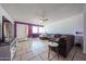 Bright living room featuring tile flooring, a ceiling fan, purple accent wall and a large sectional sofa at 4623 W Solano S Dr # South, Glendale, AZ 85301