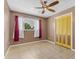 A sunlit bedroom features tile flooring, a ceiling fan, and yellow closet doors at 4632 W Marlette Ave, Glendale, AZ 85301