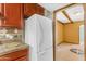 View of a white refrigerator in kitchen with granite countertops and backsplash at 4632 W Marlette Ave, Glendale, AZ 85301