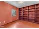 Red room features a window and a built-in wooden bookcase at 4632 W Marlette Ave, Glendale, AZ 85301