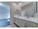 Bathroom features double sinks, bright lighting, and a large mirror with access to the main bedroom at 4927 S Tune --, Mesa, AZ 85212