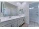 Bathroom features double sinks, bright lighting, and a large mirror with access to a bathtub at 4927 S Tune --, Mesa, AZ 85212