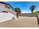 Sideyard with a neutral-toned gravel area, partial view of the house, and privacy fencing at 527 N Criss St, Chandler, AZ 85226