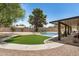 Beautiful backyard features pool, desert landscaping, synthetic grass, and covered patio at 527 N Criss St, Chandler, AZ 85226