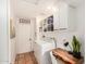 Well-organized laundry room boasts terracotta floors, white cabinets and shelving, and desk space at 527 N Criss St, Chandler, AZ 85226