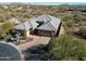 Stunning aerial view of a modern home with desert landscaping and a paver driveway at 6251 E Bramble Berry Ln, Cave Creek, AZ 85331