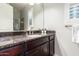 Bathroom featuring granite countertops, dark cabinetry, a sink, and ample mirror space at 6251 E Bramble Berry Ln, Cave Creek, AZ 85331