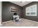 Cozy bedroom featuring a workspace, neutral carpet, grey accent wall, and a bright window at 6251 E Bramble Berry Ln, Cave Creek, AZ 85331