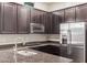 Close up on kitchen with granite countertops, stainless steel appliances and dark wood cabinetry at 6251 E Bramble Berry Ln, Cave Creek, AZ 85331