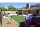 Backyard with artificial grass, covered patio, outdoor furniture, pool and spa at 6352 W Campo Bello Dr, Glendale, AZ 85308