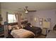 This bedroom has two beds with ceiling fan, a workstation, and purple walls at 6352 W Campo Bello Dr, Glendale, AZ 85308