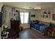 This bedroom has a daybed, dark wood laminate flooring and decor, a TV and an arcade game at 6352 W Campo Bello Dr, Glendale, AZ 85308