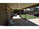 Covered patio with decorative pavers, an outdoor kitchen, a fan and an artificial lawn at 6352 W Campo Bello Dr, Glendale, AZ 85308