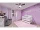 This Bedroom offers a crib, rocking chair, lavender walls, and a ceiling fan at 7111 N 63Rd Dr, Glendale, AZ 85301